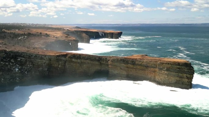 无人机拍摄的海岸悬崖被海浪拍打的画面。