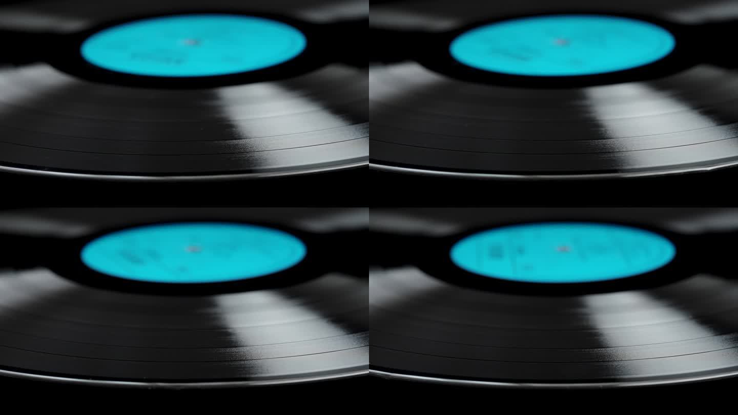 黑胶唱片的特写，蓝色标签在黑色背景上缓慢旋转。