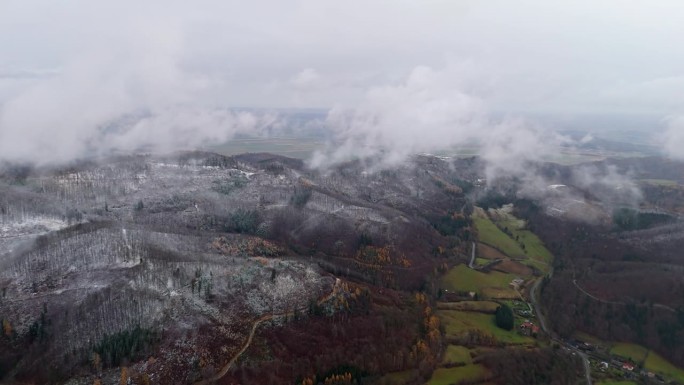 云层在积雪覆盖的山上飘过，拍摄于一个天气恶劣的冬天下午。