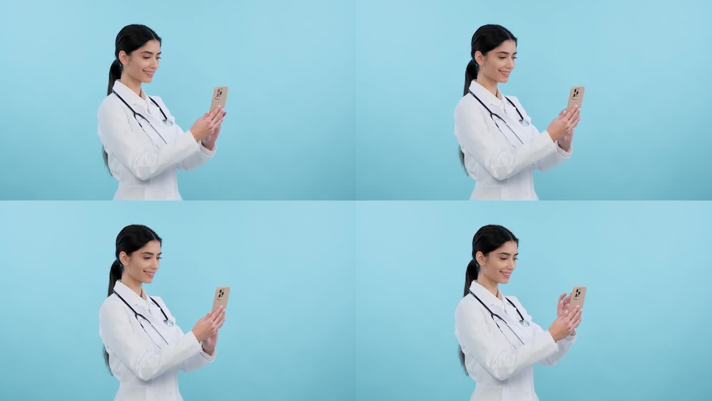 阳性的女医生使用蓝色背景的手机
