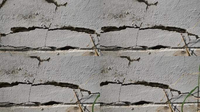 老旧混凝土墙面纹理裂缝大，墙面脏污，破损大。