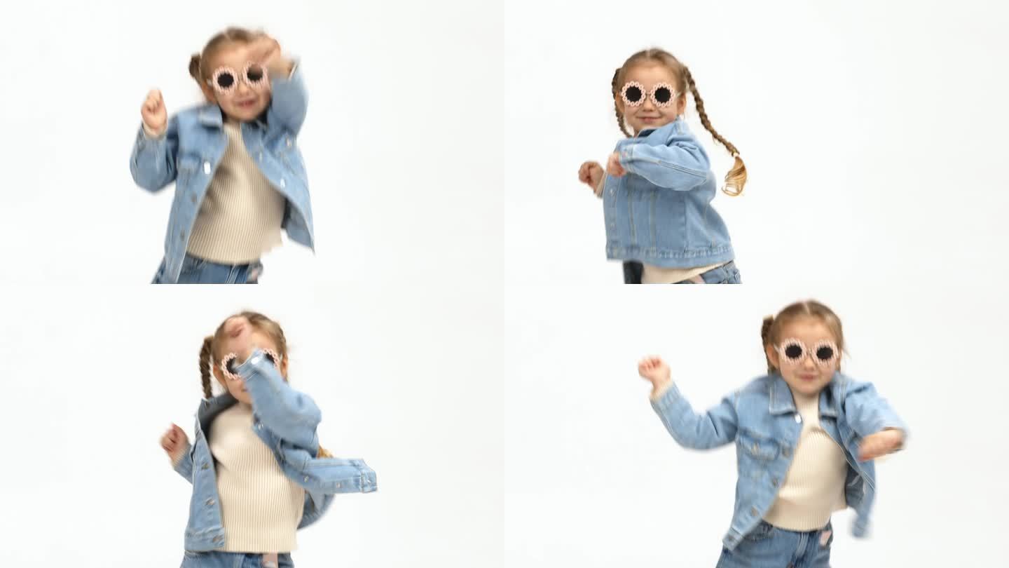 开朗的小女孩穿着现代服装，在孤立的白色背景上表演自由式舞蹈。童装广告理念