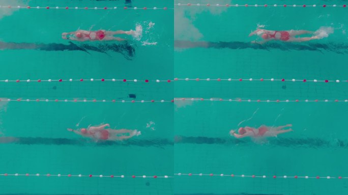 正上方的SLO MO跟踪拍摄的运动女子在游泳池游泳的红色泳衣
