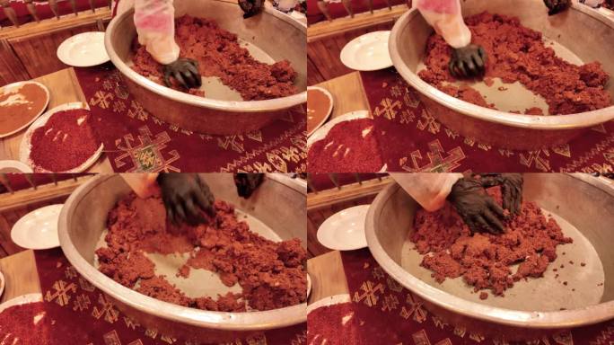 在传统的西拉之夜，一名妇女正在用慢动作在铜盘里揉制传统的土耳其生肉丸。