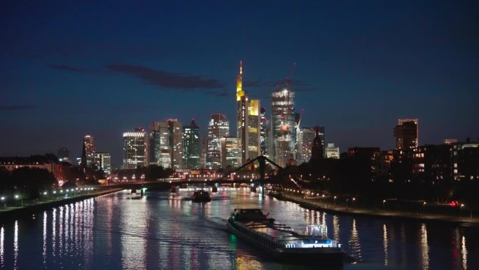 法兰克福市景金融区天际线与现代办公大楼和美因河与弗洛伯布鲁克桥在晚上在法兰克福，德国