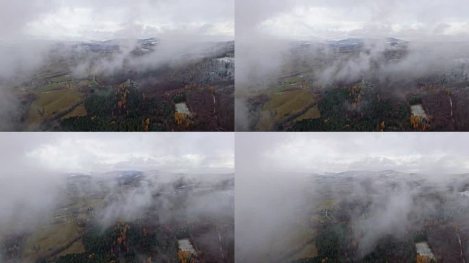 在飘落的雪和风中，无人机拍摄的一幅照片显示，寒冷的雪山被分开的云所揭示。