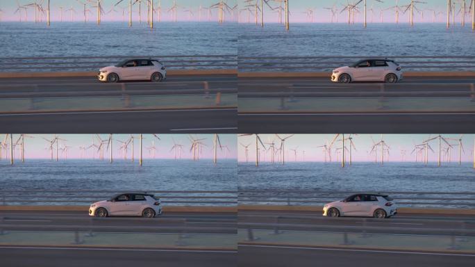 通用电动汽车行驶在一座桥上，背景是风力涡轮机