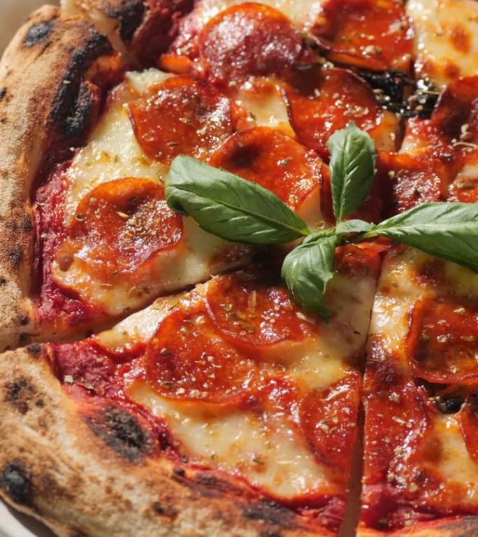 垂直夹。披萨配意大利辣香肠、马苏里拉奶酪、番茄酱、橄榄油和罗勒叶。