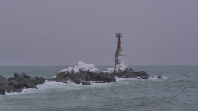 海浪冲击着冲刷过的灯塔。海上风暴，狂风，巨浪袭击灯塔。