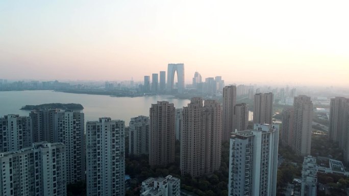 2019年4月1日，苏州，中国:日落时住宅公寓楼的航拍照片。航拍的社区公寓大楼与现代商业建筑和湖的背