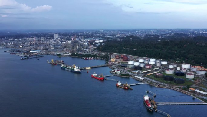 背景是停靠的油轮和印尼国家石油公司(Pertamina)炼油厂的上升视图——印尼巴厘巴班市港口