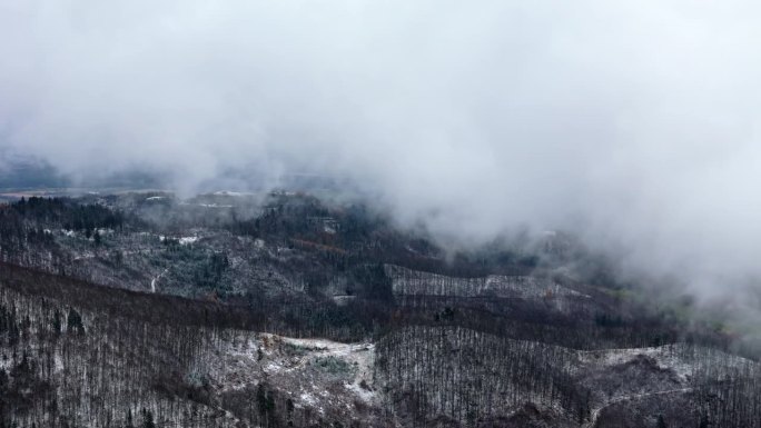 冬季山脉的俯视图，有时被云遮住，因为下雪了，风在咆哮。