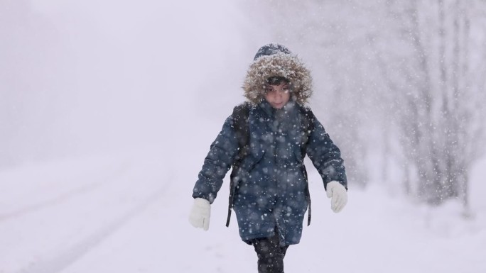 快乐的小男孩在上学的路上玩雪