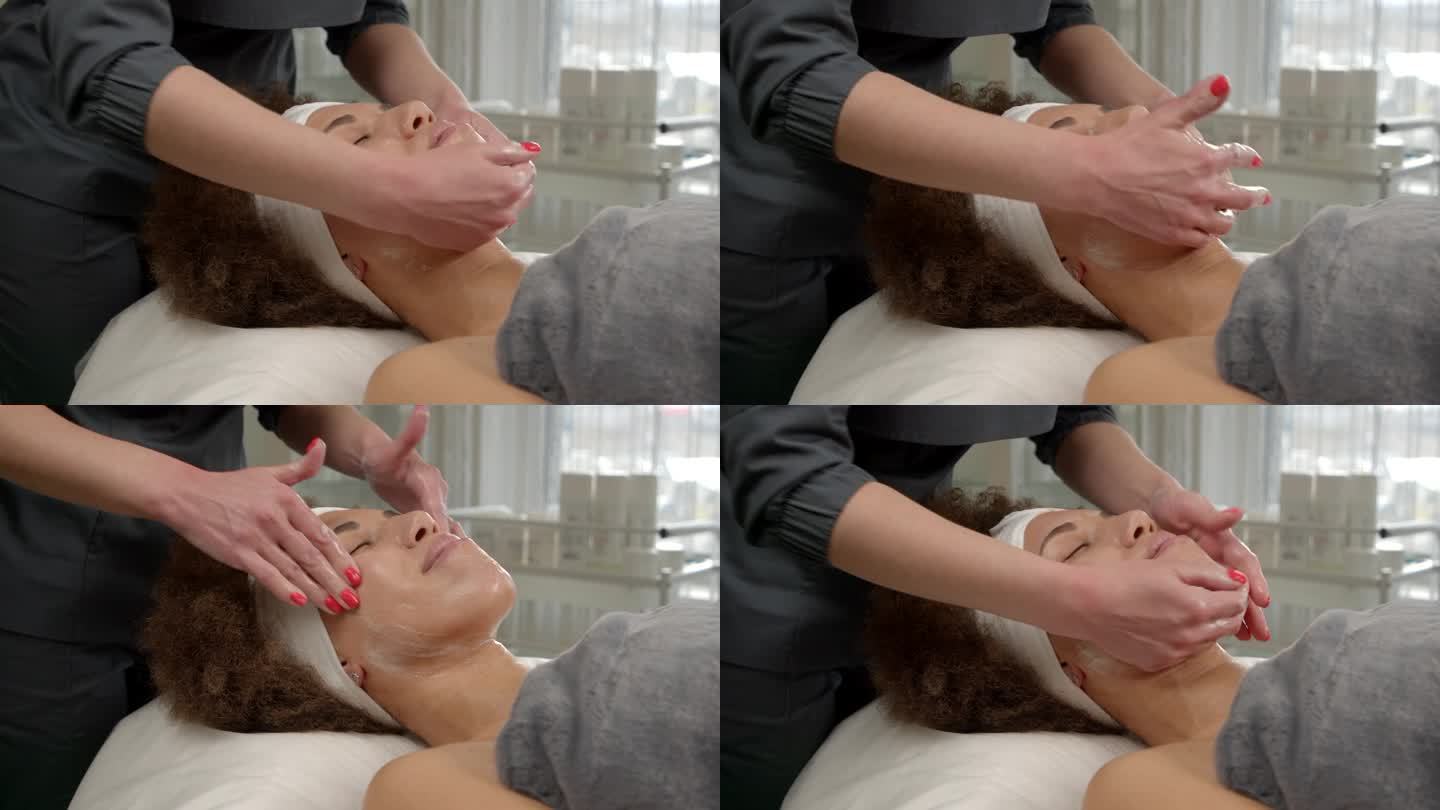 美容师在一位黑人妇女的脸上用面霜进行爽肤护理