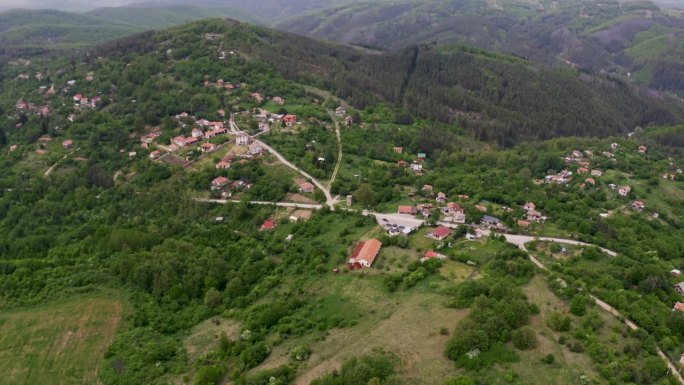 无人机从画面的左到右平移，捕捉到保加利亚偏远地区Tsarichina Hole村的风景。