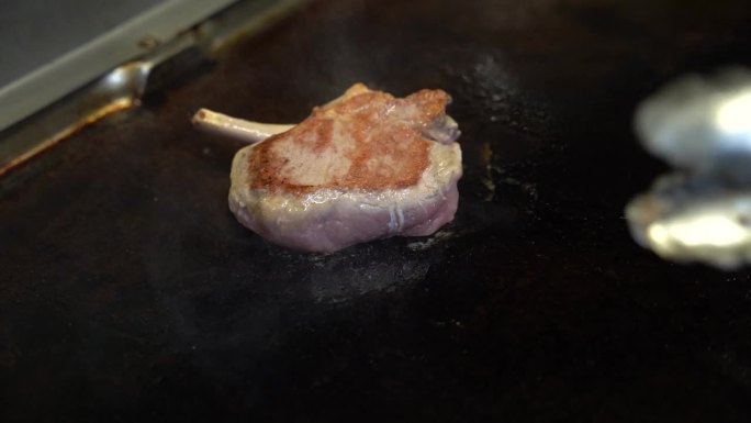 在餐馆的炉灶上烤一片肉