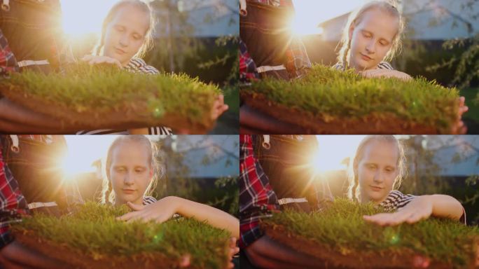 女孩抚摸着嫩绿的小草，一片长满小草的土地被农夫捧在手里。