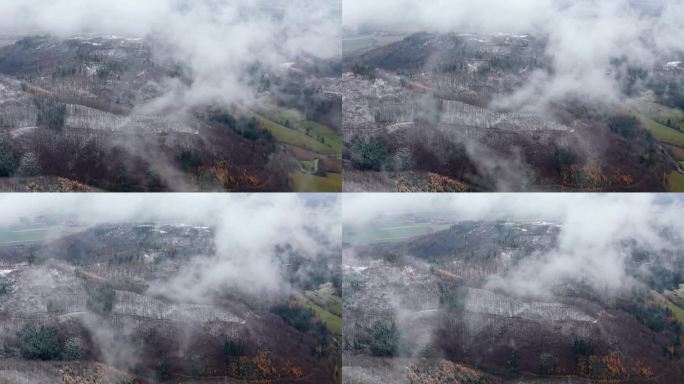 积雪覆盖着山脉，从上面看，云层散开，露出冬日的风景，无人机拍摄了这张照片。