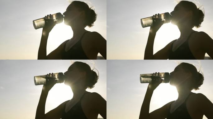 口渴的健身女性在户外锻炼后从运动瓶中喝水
