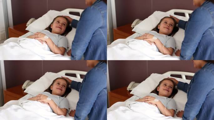 漂亮的小女孩躺在医院的病床上，非常慈爱地看着妈妈，妈妈抚摸着她的头发