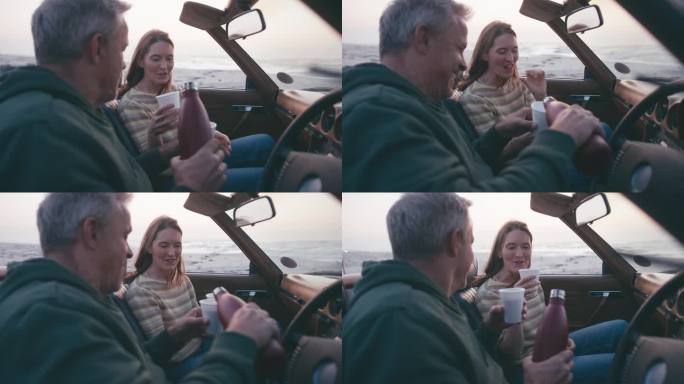 退休的高级夫妇度假坐在经典的敞篷跑车在海滩上看早晨的日出和喝咖啡的烧瓶在公路旅行的慢动作拍摄