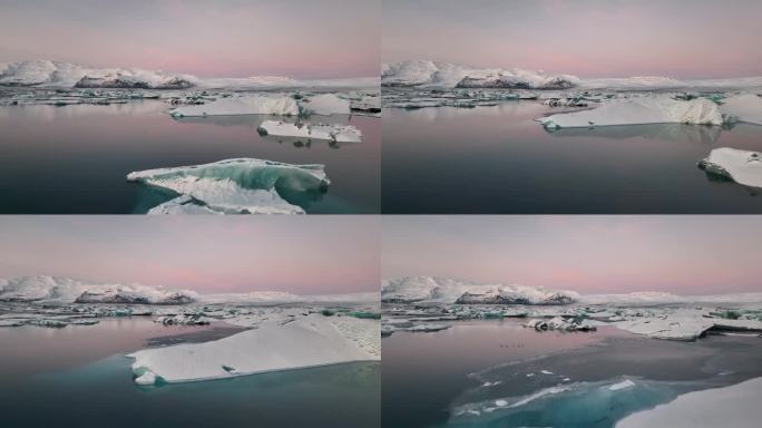 粉红色的日出天空和冰山反映在Jokulsarlon冰湖上。冰岛南部的瓦特纳冰川国家公园。无人驾驶飞机