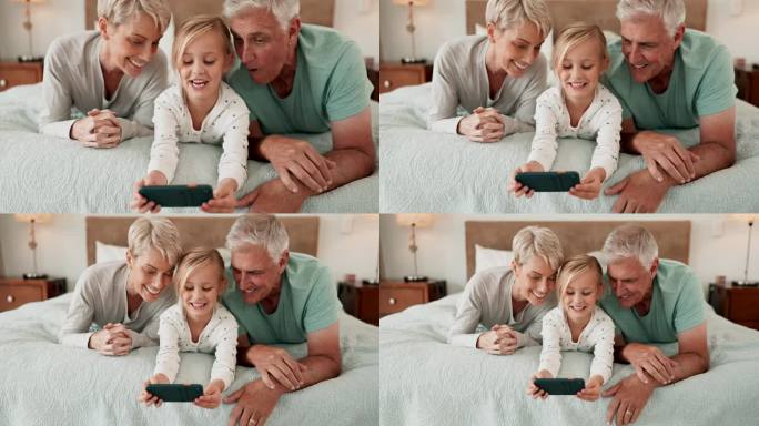 手机，游戏和一个女孩和她的祖父母在家里的床上一起玩或建立联系。爱，孩子或家庭，老人和女人带着他们的孙