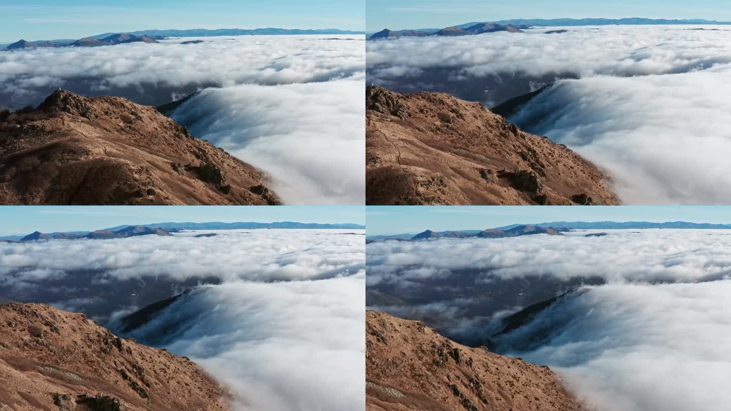 青山高耸云海，碧蓝晴空下，远处孤独的身影