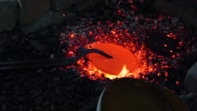 在一家工厂里，一块青铜正在燃烧着煤。一家传统的铜、黄铜家电工厂。