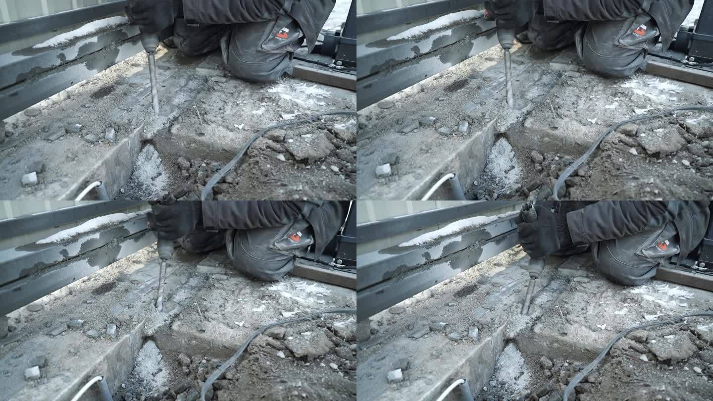 建筑工用锤子在墙上钻一个洞。冲击钻射孔器打孔特写