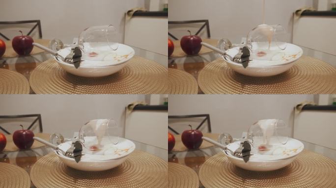 白色的乳白色的粘稠物倒在厨房桌子上的一堆脏盘子上。