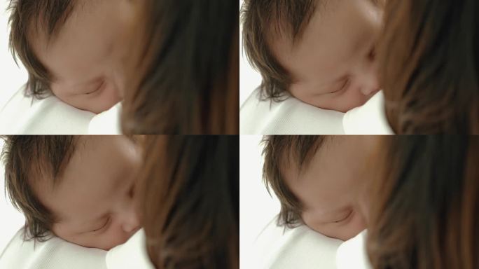 婴儿或新生婴儿进入深度睡眠快乐的单身妈妈背着小婴儿保护宁静的睡眠照顾健康舒适安全小孩妈妈哄宝宝睡觉