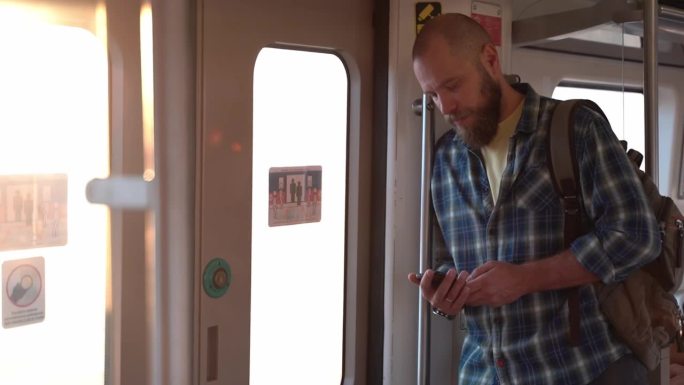 城市居民带着背包坐地铁或火车。一个去上班的成年人，在公共交通工具上使用手机。市民早晨的城市生活依赖于