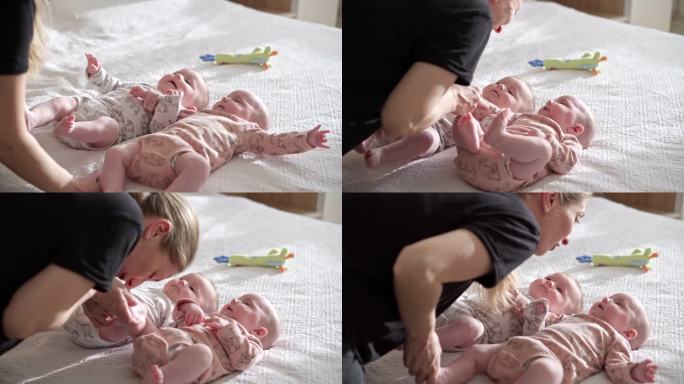 一位母亲在床上玩耍并给她的孩子挠痒痒的特写镜头——斯托克视频