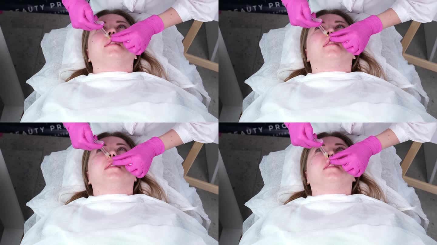 在医疗美容办公室里，一位美容师给一位美丽的年轻女子注射的特写镜头。概念的整容注射，手术和药物。
