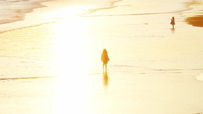 夕阳剪影 女人在海滩孤独走着