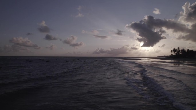 一群人与他们的船在黎明期间在普拉亚达巴利亚，伊塔皮波卡- CE，巴西。