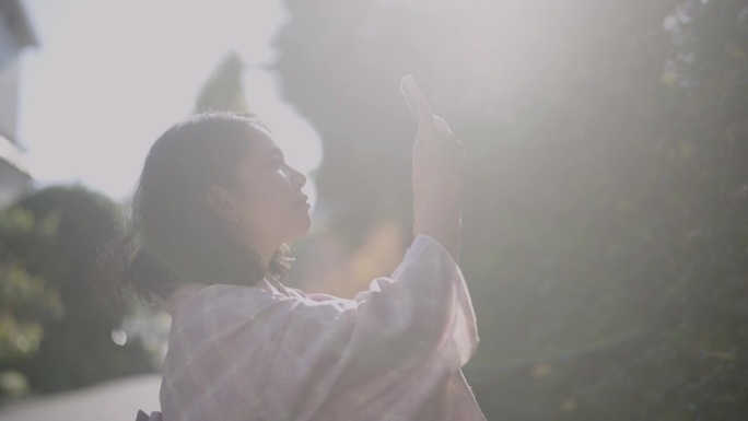 秋天，身穿和服的微笑女子在浅草寺用智能手机拍摄照片和视频。
