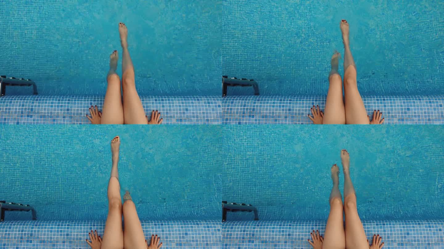 女子在清澈碧蓝的游泳池里荡着腿。暑假