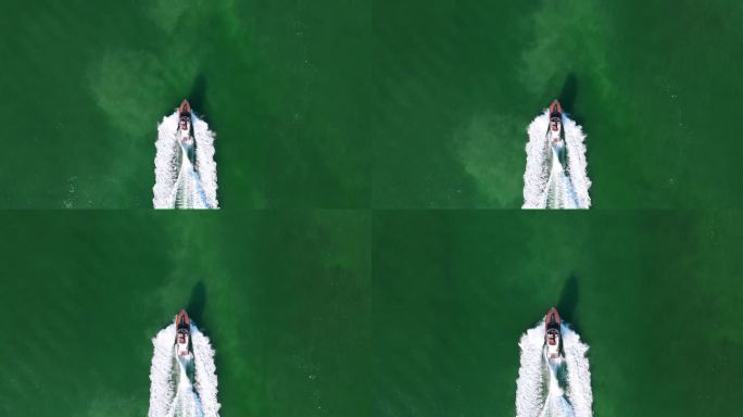 时尚的快艇装饰着红白相间的色调，巡游在广阔的深海郁郁葱葱的绿色水域，留下泡沫的尾迹。豪华探险