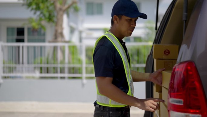 送货员检查订单地址和包裹包装，准备送货给客户。从货车上卸下箱子。