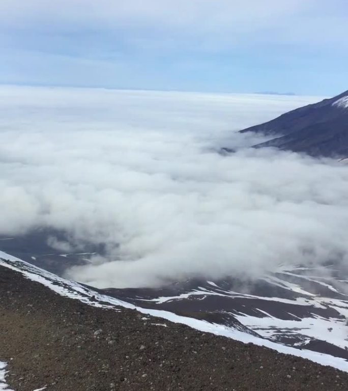 Koryaksky火山的峰顶在云层上升起