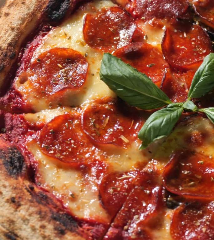 垂直夹。披萨配意大利辣香肠、马苏里拉奶酪、番茄酱、橄榄油和罗勒叶。