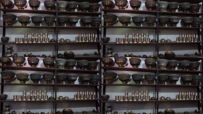 铜黄铜器具陈列在木制橱柜里。