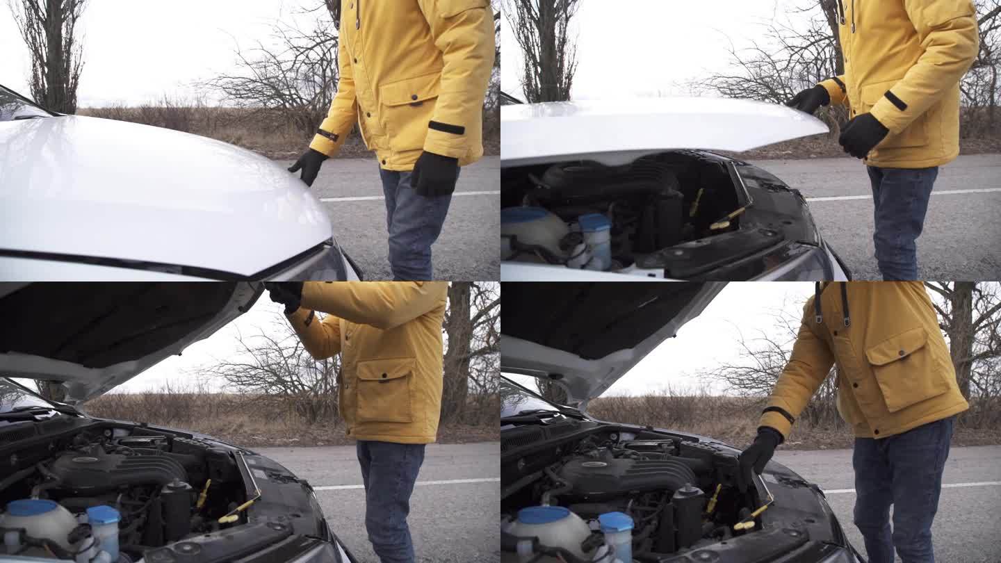 一名男子打开一辆汽车的引擎盖，试图找出问题所在。