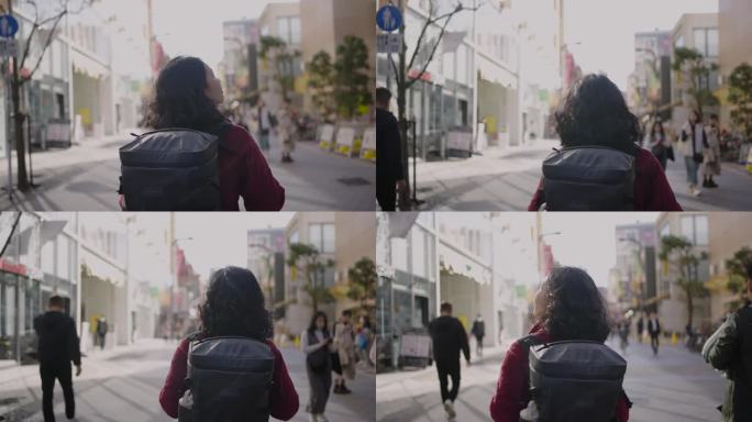亚洲年轻女性背包客在东京城市散步和环顾四周。