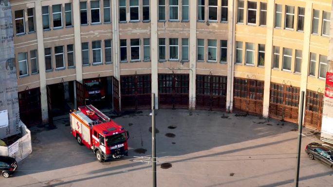 旧消防站大楼的4K航拍视频，院子里有消防车
