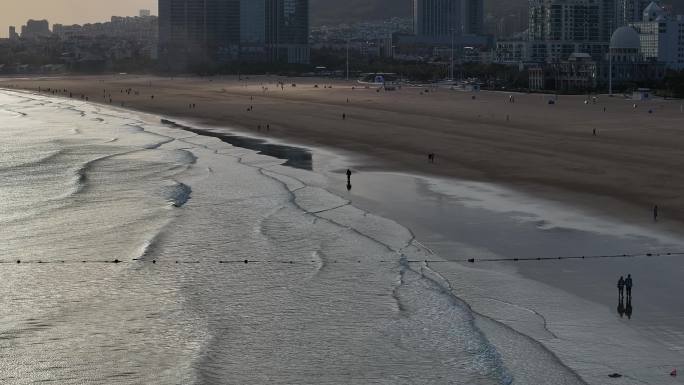 青岛石老人浴场海边航拍逆光行人