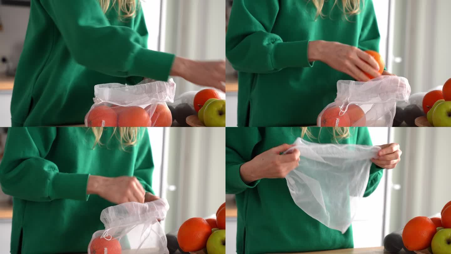 特写镜头拍摄的可重复使用的袋子与橙子。购物后，可持续生活的女人从可重复使用的袋子里取出橙子。