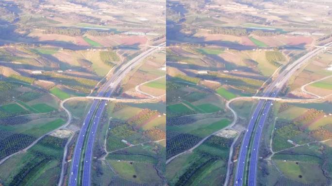 无人机捕捉高速公路上的交通，穿过绿色的田野，蓝天。航拍画面展示了高速公路和乡村。探索高速公路、乡村风